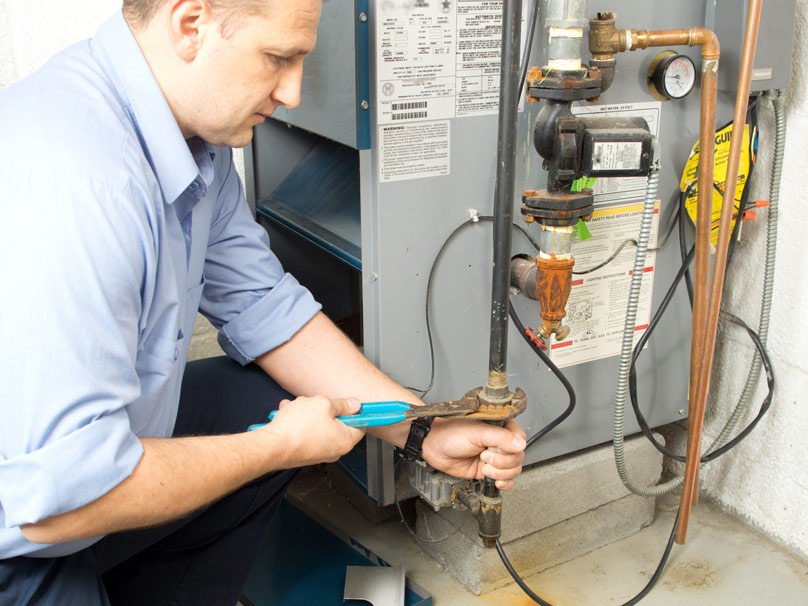 Man repairing a furnace in a home